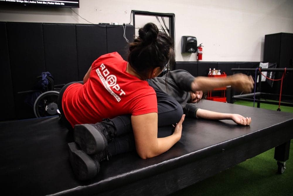 ADAPT physical therapist working with a client on a treatment table