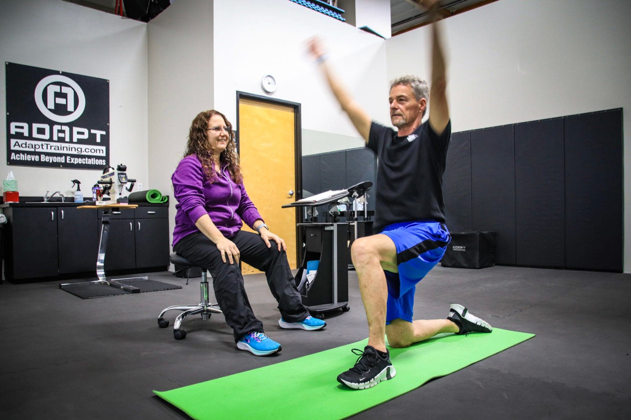 Older male client performing kneeling mobility work with an ADAPT physical therapist