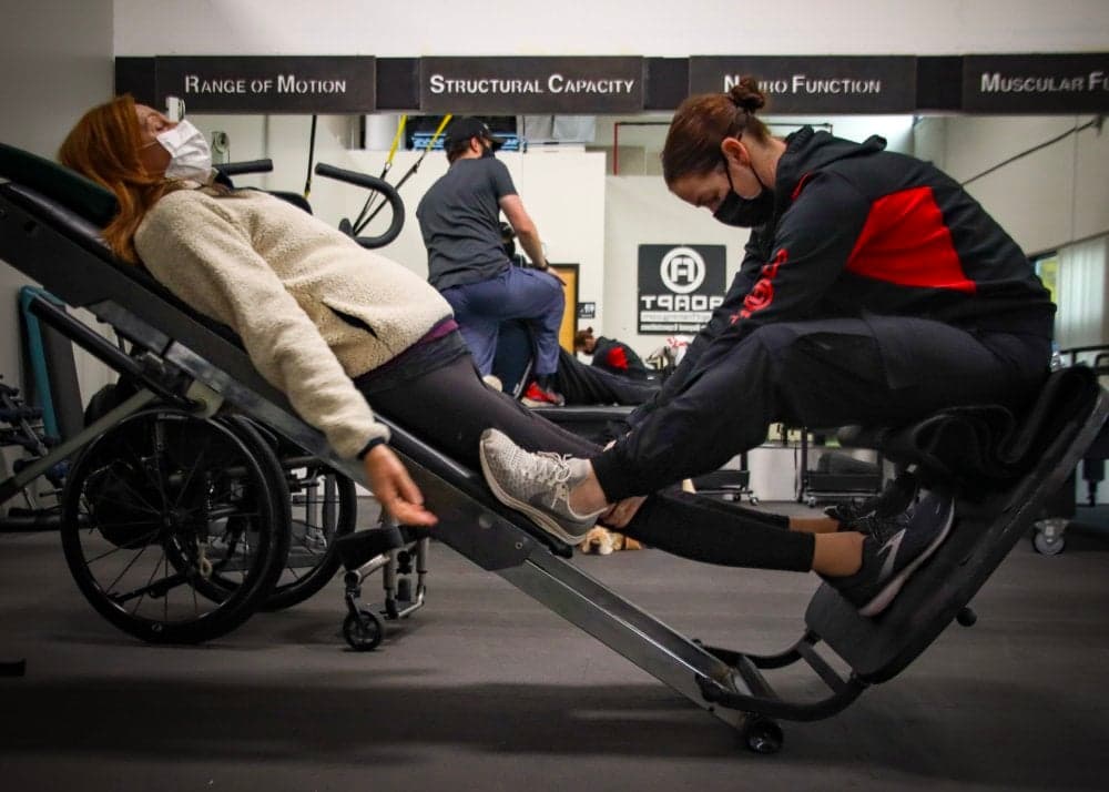 ADAPT Advanced specialist working with a wheelchair user on a recline trainer